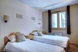 Discover a cozy bedroom featuring two comfortable beds, perfect for a relaxing stay.