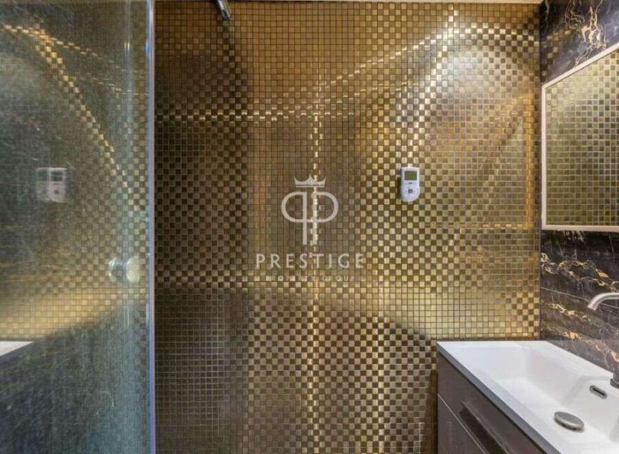 Step into luxury with this stunning bathroom featuring a unique gold mosaic tile design.