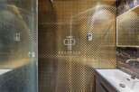 Step into luxury with this stunning bathroom featuring a unique gold mosaic tile design.