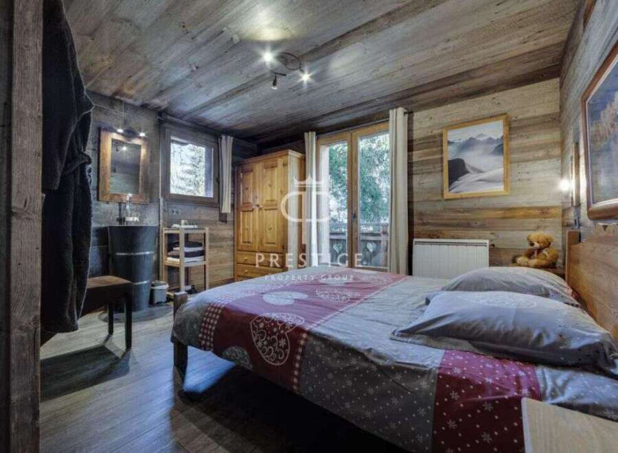Experience rustic charm in this cozy bedroom, featuring wooden walls and a warm ambiance.