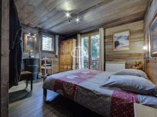 Experience rustic charm in this cozy bedroom, featuring wooden walls and a warm ambiance.