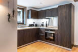 Modern kitchen with dark wood cabinets and integrated appliances.