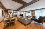 This stunning apartment boasts a spacious open-plan living area with hardwood floors, a modern dining table, and comfortable seating.