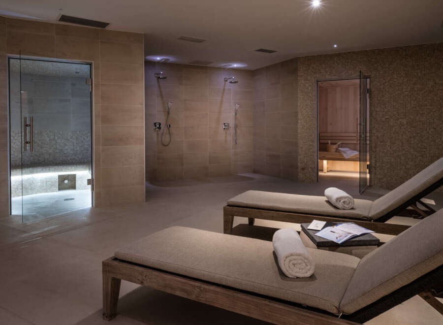 Relax and rejuvenate in our luxurious spa, featuring a tranquil sauna, invigorating showers, and comfortable lounge chairs perfect for unwinding after your spa treatment.