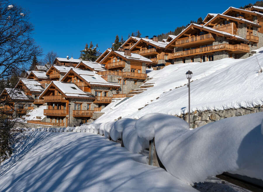 Luxury chalet homes nestled on a snowy hillside, offering stunning mountain views and breathtaking winter landscapes.