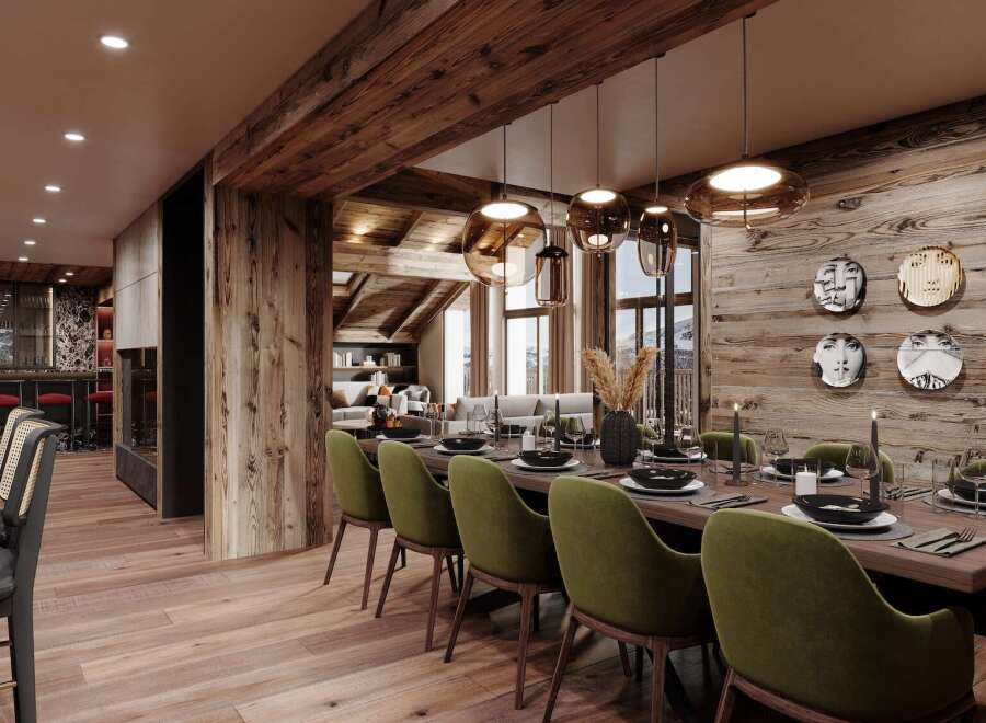 This luxurious chalet boasts a stunning open-plan dining area with a long wooden table, plush green chairs, and unique wall art.
