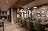 This luxurious chalet boasts a stunning open-plan dining area with a long wooden table, plush green chairs, and unique wall art.