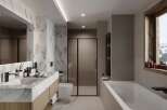 This luxurious bathroom boasts a stunning marble vanity with double sinks, complemented by sleek black fixtures.