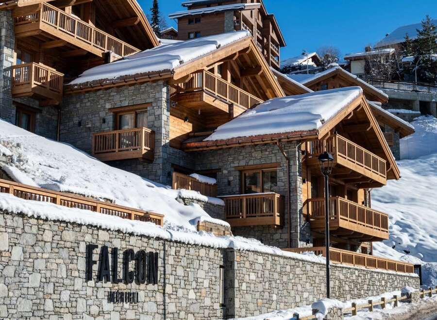 Nestled in a snow-covered mountainside, Falcon Megève offers luxurious chalets with stunning wooden balconies and stone exteriors.