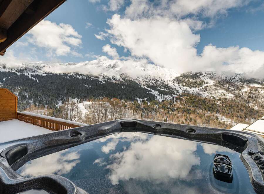 Indulge in luxury with this stunning property featuring a private hot tub overlooking breathtaking mountain views.