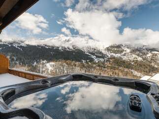 Indulge in luxury with this stunning property featuring a private hot tub overlooking breathtaking mountain views.