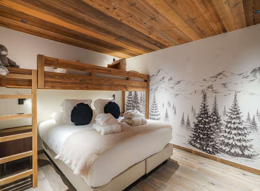 This cozy bedroom features a unique bunk bed design with a warm wooden aesthetic, perfect for a family or group getaway.