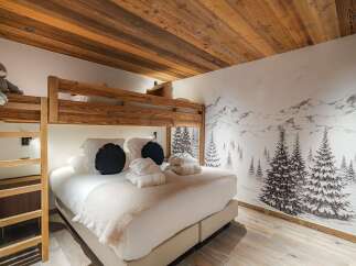 This cozy bedroom features a unique bunk bed design with a warm wooden aesthetic, perfect for a family or group getaway.