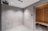 Step into luxury with this stunning bathroom featuring a modern shower and a relaxing sauna.