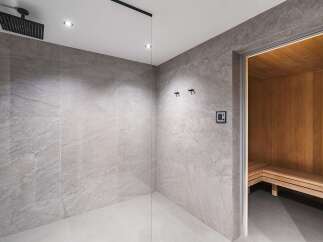 Step into luxury with this stunning bathroom featuring a modern shower and a relaxing sauna.