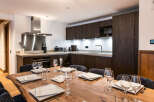 This stunning apartment boasts a modern kitchen with sleek dark wood cabinetry, stainless steel appliances, and a large island perfect for entertaining.
