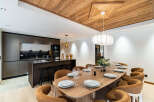 Experience luxury living in this stunning property featuring a modern kitchen with sleek cabinetry and a breakfast bar.