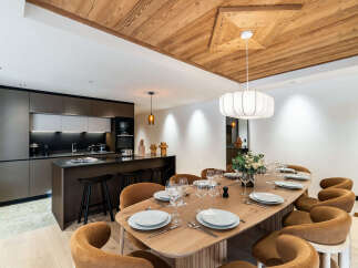 Experience luxury living in this stunning property featuring a modern kitchen with sleek cabinetry and a breakfast bar.