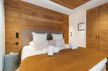 Experience luxury in this exquisite bedroom featuring stunning wooden accents and a cozy ambiance.