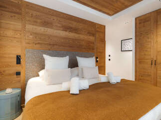 Experience luxury in this exquisite bedroom featuring stunning wooden accents and a cozy ambiance.
