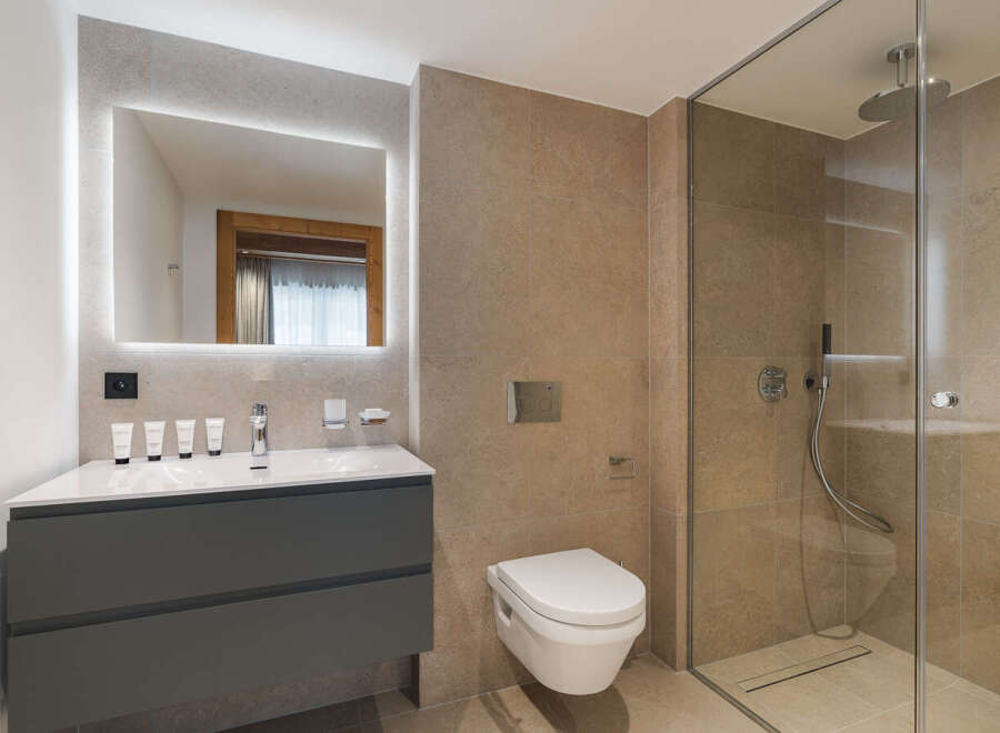 This modern bathroom features a sleek design with a spacious walk-in shower and a stylish vanity.