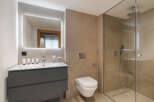 This modern bathroom features a sleek design with a spacious walk-in shower and a stylish vanity.