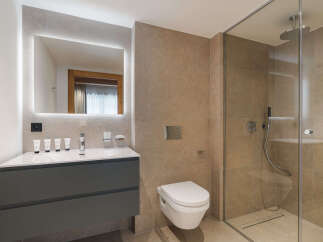 This modern bathroom features a sleek design with a spacious walk-in shower and a stylish vanity.