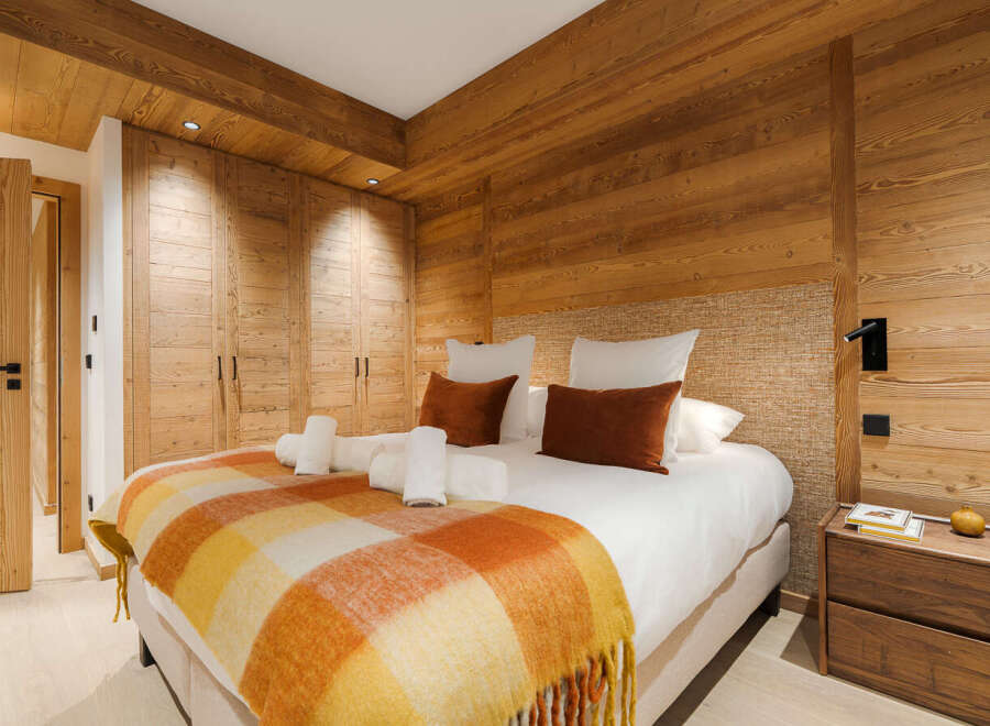 This stunning bedroom boasts a warm and inviting ambiance, perfect for a relaxing retreat.