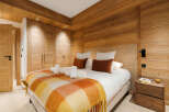 This stunning bedroom boasts a warm and inviting ambiance, perfect for a relaxing retreat.