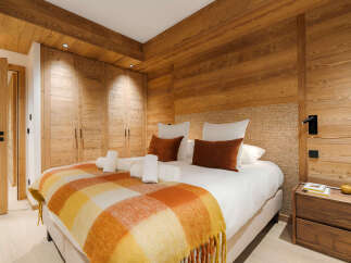 This stunning bedroom boasts a warm and inviting ambiance, perfect for a relaxing retreat.