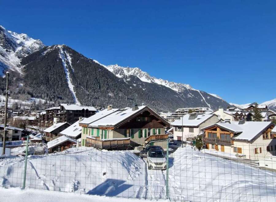Experience the charm of a snow-covered village nestled against majestic mountains.