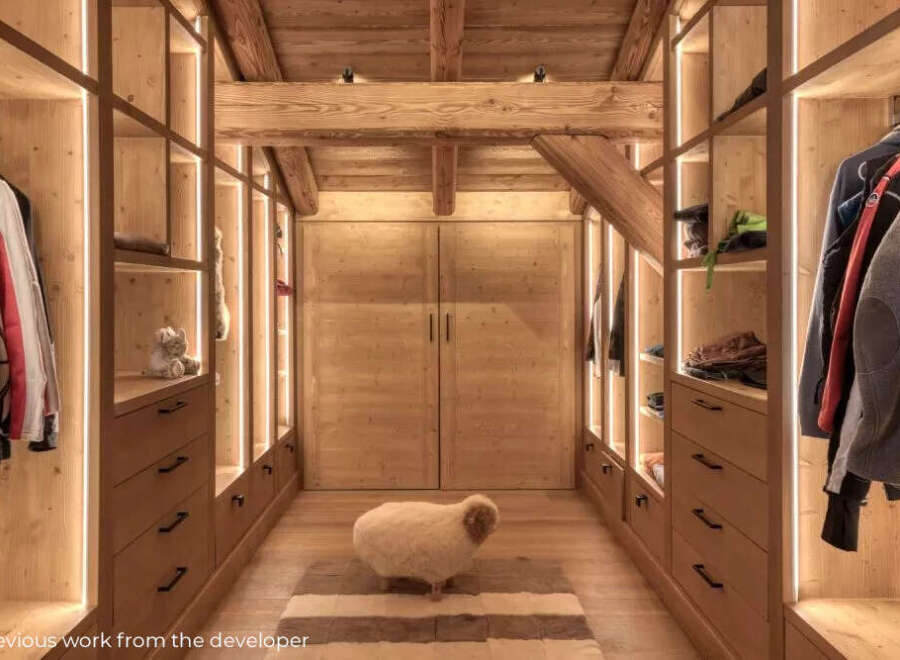 Step into luxury with this stunning walk-in closet, showcasing exquisite wooden craftsmanship and ambient lighting.