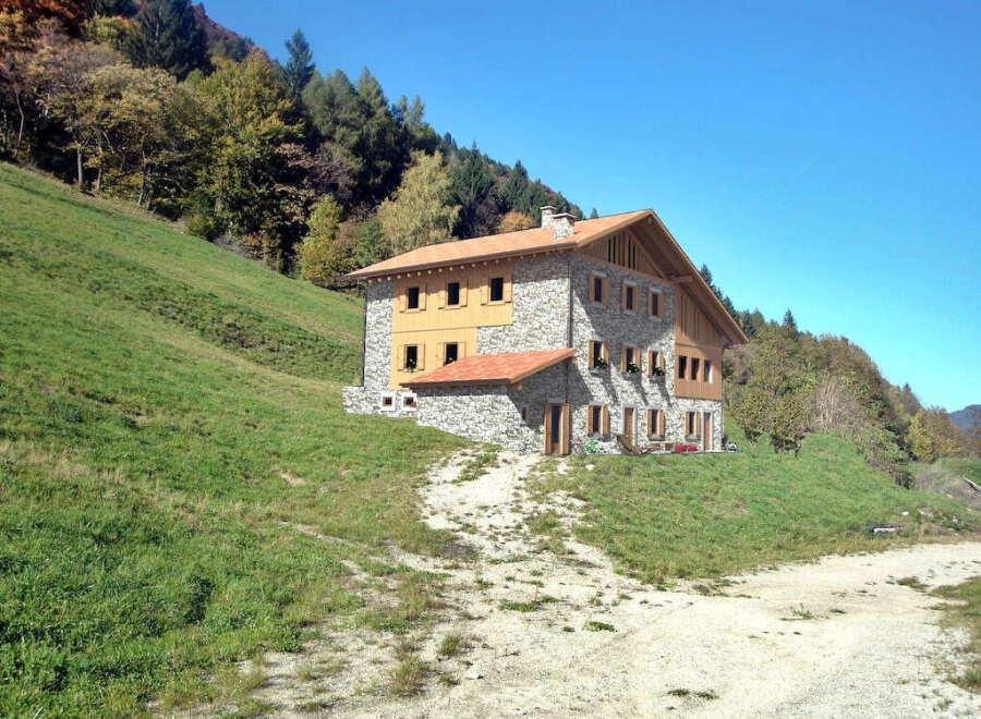 Nestled in a picturesque mountain setting, this stunning property boasts a charming stone facade and a warm, inviting wooden gable.