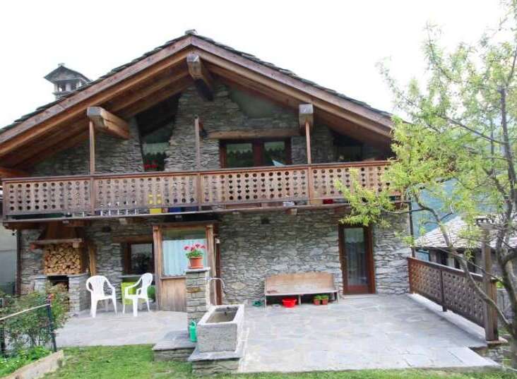 Discover the charm of this stone-built house, featuring a cozy balcony and a rustic wooden facade.