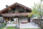Discover the charm of this stone-built house, featuring a cozy balcony and a rustic wooden facade.