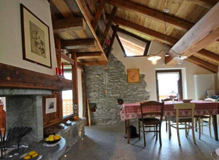 This charming property boasts a rustic interior with exposed wooden beams and a stone fireplace, creating a warm and inviting atmosphere.