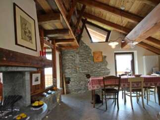 This charming property boasts a rustic interior with exposed wooden beams and a stone fireplace, creating a warm and inviting atmosphere.