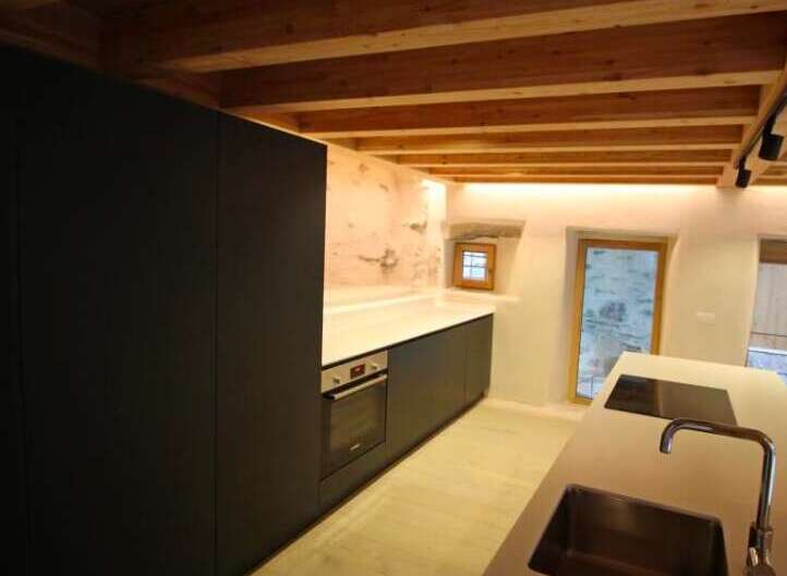 This stunning kitchen boasts a modern design with sleek black cabinetry and a minimalist aesthetic.