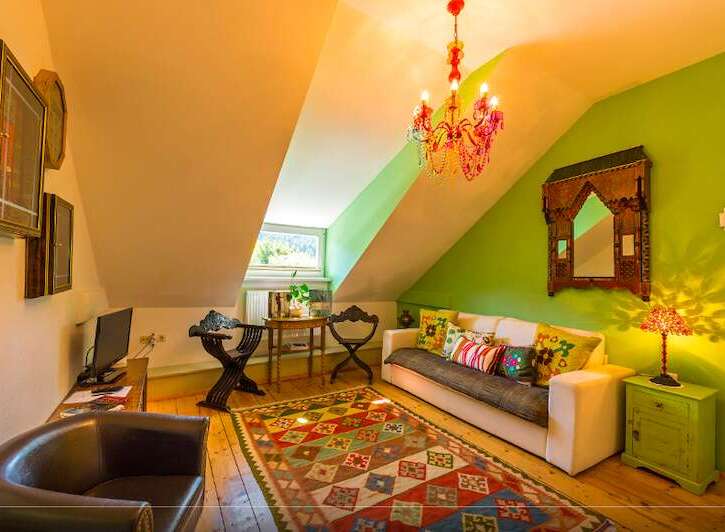Discover the charm of this unique property, featuring a cozy living room with a vibrant rug and comfortable seating.