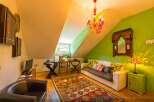 Discover the charm of this unique property, featuring a cozy living room with a vibrant rug and comfortable seating.