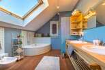 This stunning bathroom boasts a unique design with a skylight, creating a bright and airy atmosphere.