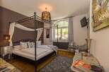 Experience luxury in this elegant bedroom featuring a stunning four-poster bed and a stylish chandelier.