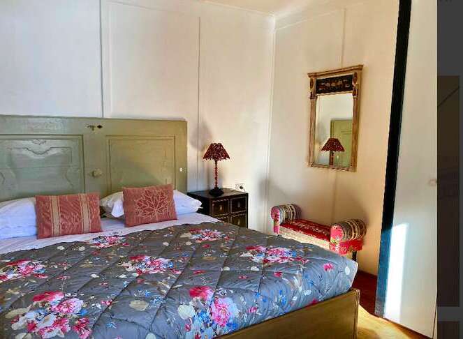 This charming bedroom features a unique headboard crafted from repurposed doors, adding character and a touch of vintage flair.