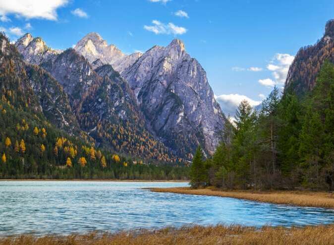 Explore the breathtaking beauty of this stunning landscape, featuring majestic mountains and a serene lake.