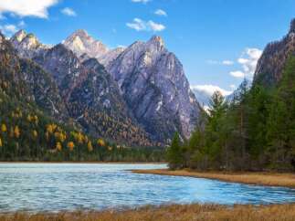 Explore the breathtaking beauty of this stunning landscape, featuring majestic mountains and a serene lake.