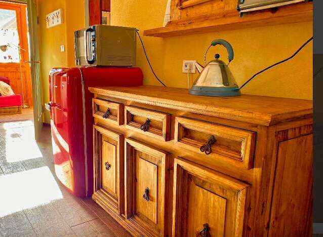 Discover the charm of this cozy property, featuring a well-equipped kitchen with a retro refrigerator and a stylish wooden cabinet.