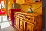 Discover the charm of this cozy property, featuring a well-equipped kitchen with a retro refrigerator and a stylish wooden cabinet.