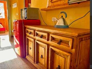 Discover the charm of this cozy property, featuring a well-equipped kitchen with a retro refrigerator and a stylish wooden cabinet.