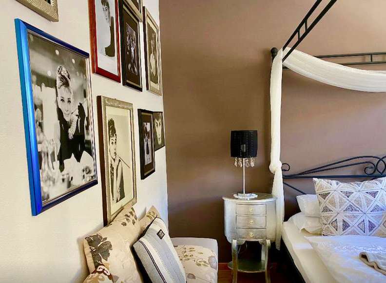 This charming bedroom features a gallery wall with elegant framed artwork.