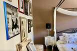 This charming bedroom features a gallery wall with elegant framed artwork.